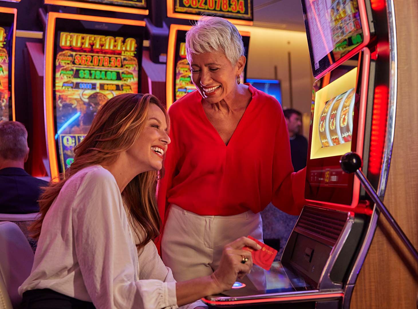 Two women playing slots at a casino